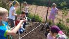 2021 - Getreide und Kartoffel - 01 - Kinder im Beet mit Maßstab